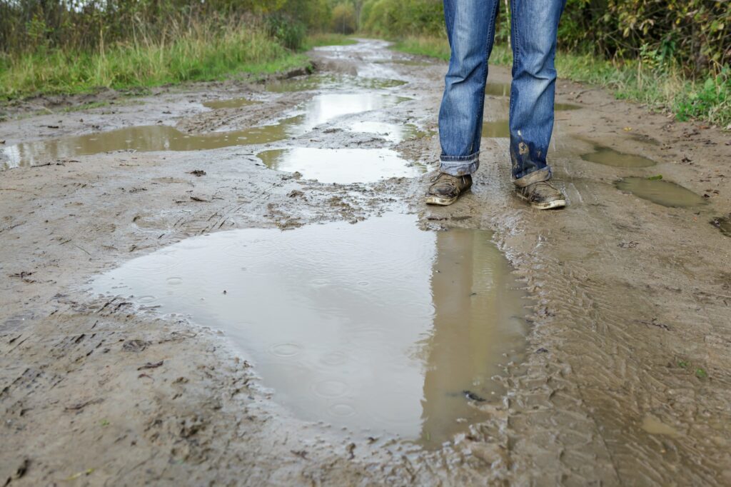 Man in dirty shoes standing in the mud