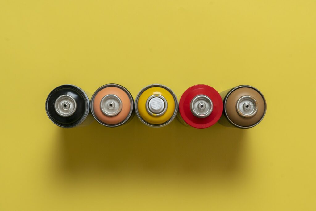 a single simple spray paint can isolated on colorful background